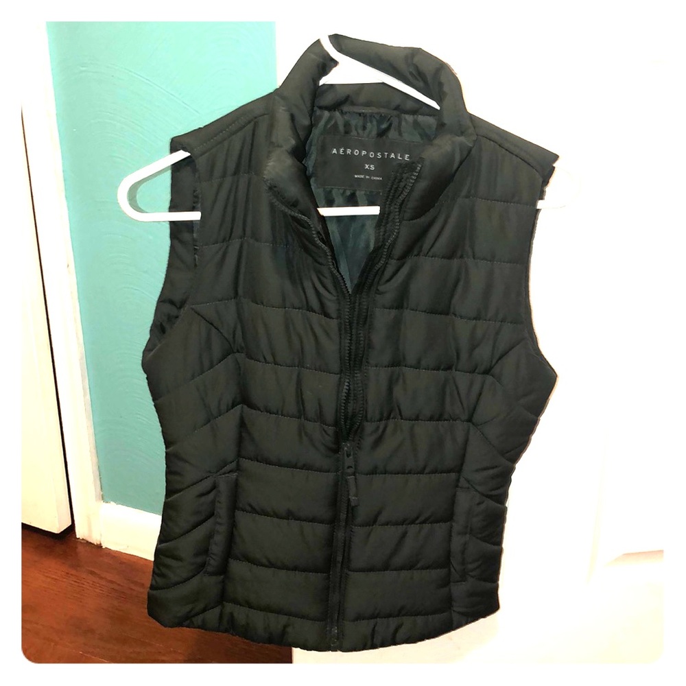 A dark green vest with a zipper in the front